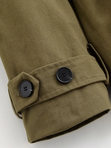 Detail of army green cargo jacket cuff showing twill fabric texture and black buttons
