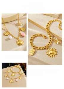 Detail of vintage gold chain jewelry set with sun pendants and decorative beads