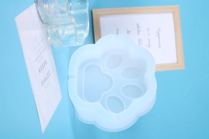 Macro view of cat claw shaped silicone mold for DIY resin art on light blue background