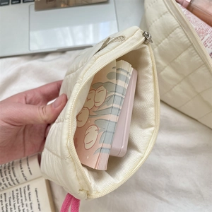 Interior view of quilted cream storage bag showing spacious capacity for cosmetics