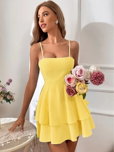 Detail of a yellow layered ruffle mini dress with slim straps and bow-tie waist