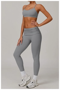 Detail of high-waist yoga pants with cross-over waistband and grey matte fabric texture