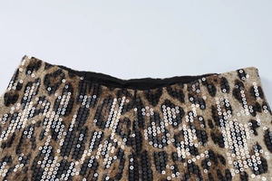 Détail rapproché du tissu imprimé léopard sexy avec des paillettes et coutures fines