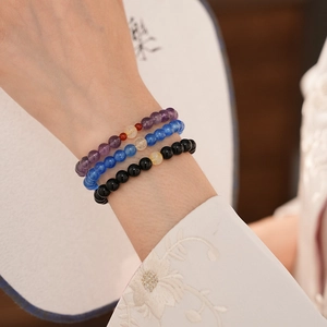 Detailed shot of obsidian and amethyst beaded bracelets in New Chinese style on wrist