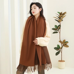 Detailed view of the dark brown thick cashmere-like scarf with fringe tassels on model