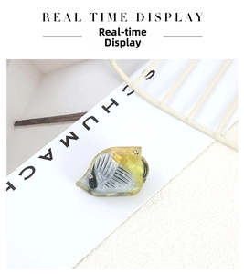 Detailed view of yellow fish-shaped acetate hair clip with rhinestones and bone pattern