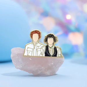 Enamel brooch with couple figure design on pink gemstone against bokeh lights background
