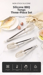 Three-piece stainless steel and cream silicone kitchen tong set on marble surface