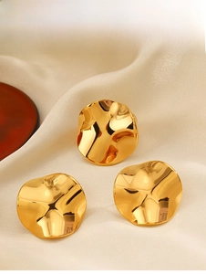 Macro detail of 18K gold-plated irregular wavy jewelry set on elegant white silk fabric