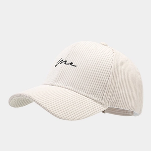 Gros plan sur une casquette en velours côtelé beige avec broderie noire détaillée