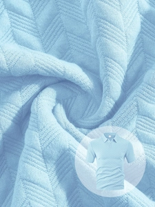 Gros plan sur le polo bleu clair montrant la texture du tricot à chevrons respirant