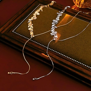 Detail of gold and silver sequin tassel necklaces with leaf patterns and adjustable sliders