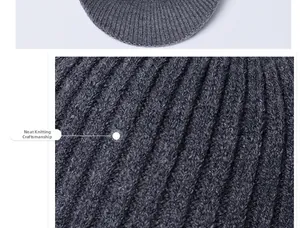 Close-up of dark grey winter knitted hat showing the dense rib knitting process and thick texture