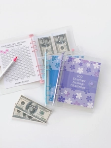 Close-up of A5 money saving challenge binder with pink tracking cards and numbered envelopes