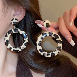 Close-up of leopard print hoop earrings made of resin on a model for fashion style