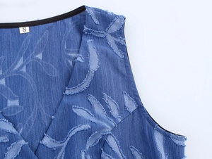 Detail of V-neckline on denim jacquard vest featuring frayed leaf pattern and S size label