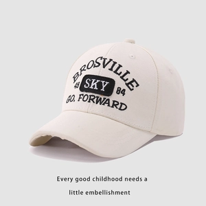Detailed close-up of premium embroidery on light beige kids cotton baseball cap