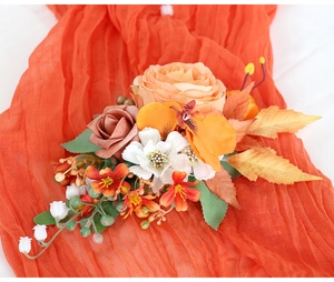 Vue détaillée du corsage de mariée fait main avec roses oranges sur fond de tissu en soie