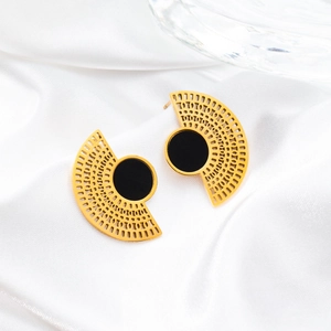 Detail of fan-shaped gold titanium steel earrings with black inlay on white silk