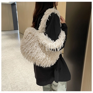 Détail de la texture d'un sac cabas en fausse fourrure blanche porté par un mannequin