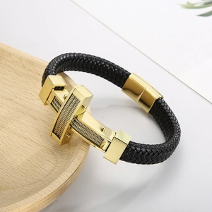 Detail of black braided leather men's bracelet with gold cross and steel wire accent