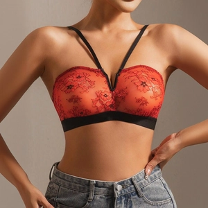 Detail of red floral lace bra showing black cross-straps and intricate sheer texture