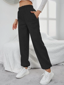 Dettaglio di joggers neri a vita alta con fascia elastica e tasche laterali capienti