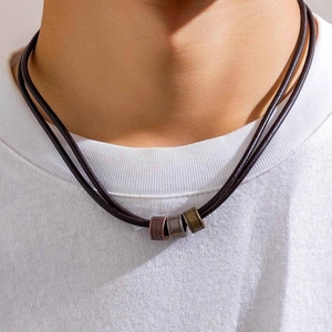 Men's leather knot necklace with bronze cylindrical beads on white t-shirt