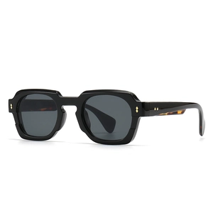 Modern rectangular black sunglasses with gold metal rivets and thick designer frames
