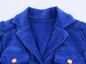 Dettaglio del risvolto dell'abito in ciniglia blu reale con bottoni dorati