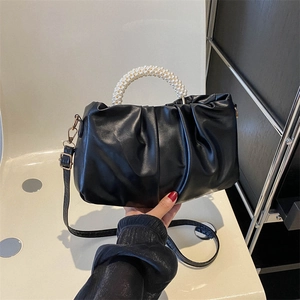 Black ruched handbag with pearl bead handle and slim strap for shoulder or crossbody use