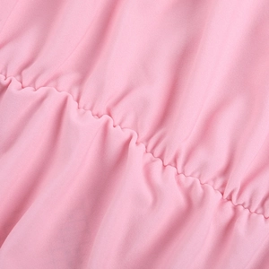Gros plan du tissu rose froncé montrant les détails de couture et la texture élastique