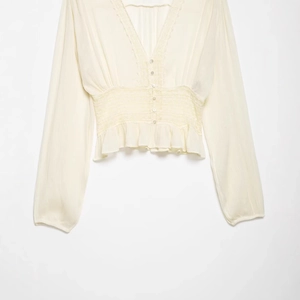Women's cream lace blouse with V-neck, button front, and cinched waist detailing
