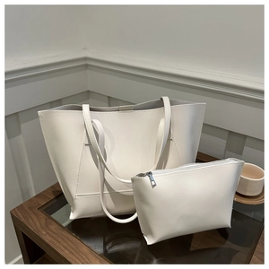 Detailed view of cream PU leather tote bag set with matching inner pouch on wooden table
