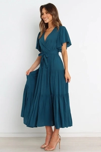 Detalle de vestido largo con cuello en V en azul verdoso y mangas con volantes y lazo