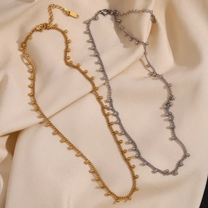 Minimalist 18K gold and silver stainless steel bead fringe necklaces on silk fabric