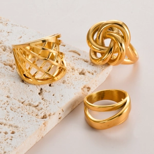 Three gold minimalist stainless steel rings including knotted and hollowed mesh designs
