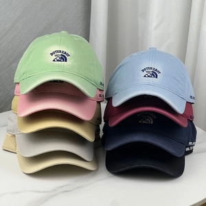 Gros plan de casquettes de baseball brodées en plusieurs couleurs sur marbre