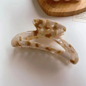 Retro tortoiseshell acetate claw clip in moon shape with vintage ivory and brown patterns