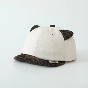 Détail des oreilles de chat à motif léopard et étiquette sur une casquette enfant