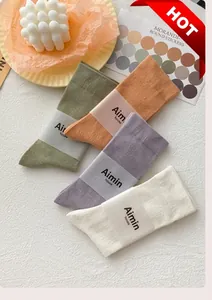 Vue à plat de chaussettes en coton aux tons Morandi avec étiquettes en papier