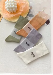 Flat lay of cotton mid-calf socks in Morandi colors with paper branding tags