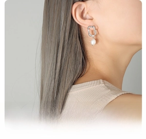 Detail of irregular hammer-textured frame with a teardrop pearl on model's ear