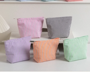 Close-up of five colorful seersucker striped cosmetic bags with metal zippers and texture