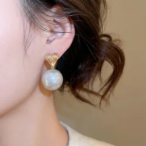 Elegant heart-shaped gold studs with large iridescent pearls for a stylish feminine look