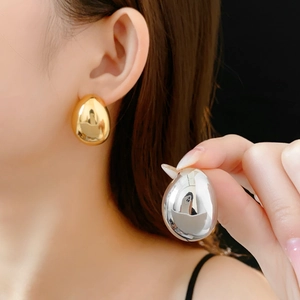 Comparaison détaillée de boucles d'oreilles gouttes plaquées or et argent sur modèle