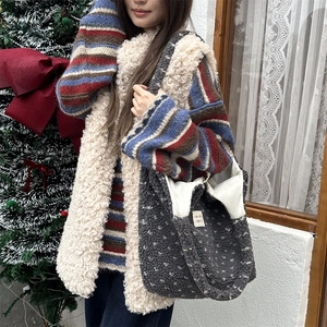 Close-up of grey fleece tote bag with a white label in a cozy winter holiday setting