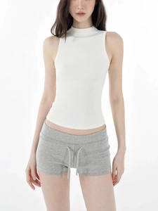 Detail von weißem Neckholder-Top und grauen Tunnelzug-Shorts an einem Model