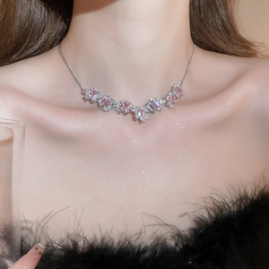 Close-up of silver necklace with pink and clear square flower zircon pendant on model