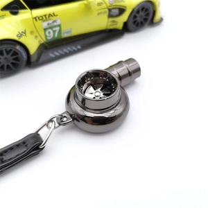Macro view of gunmetal turbo keychain with rotating blades and black leather strap